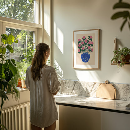 A person standing by a kitchen counter, looking out the window, with sunlight streaming in.