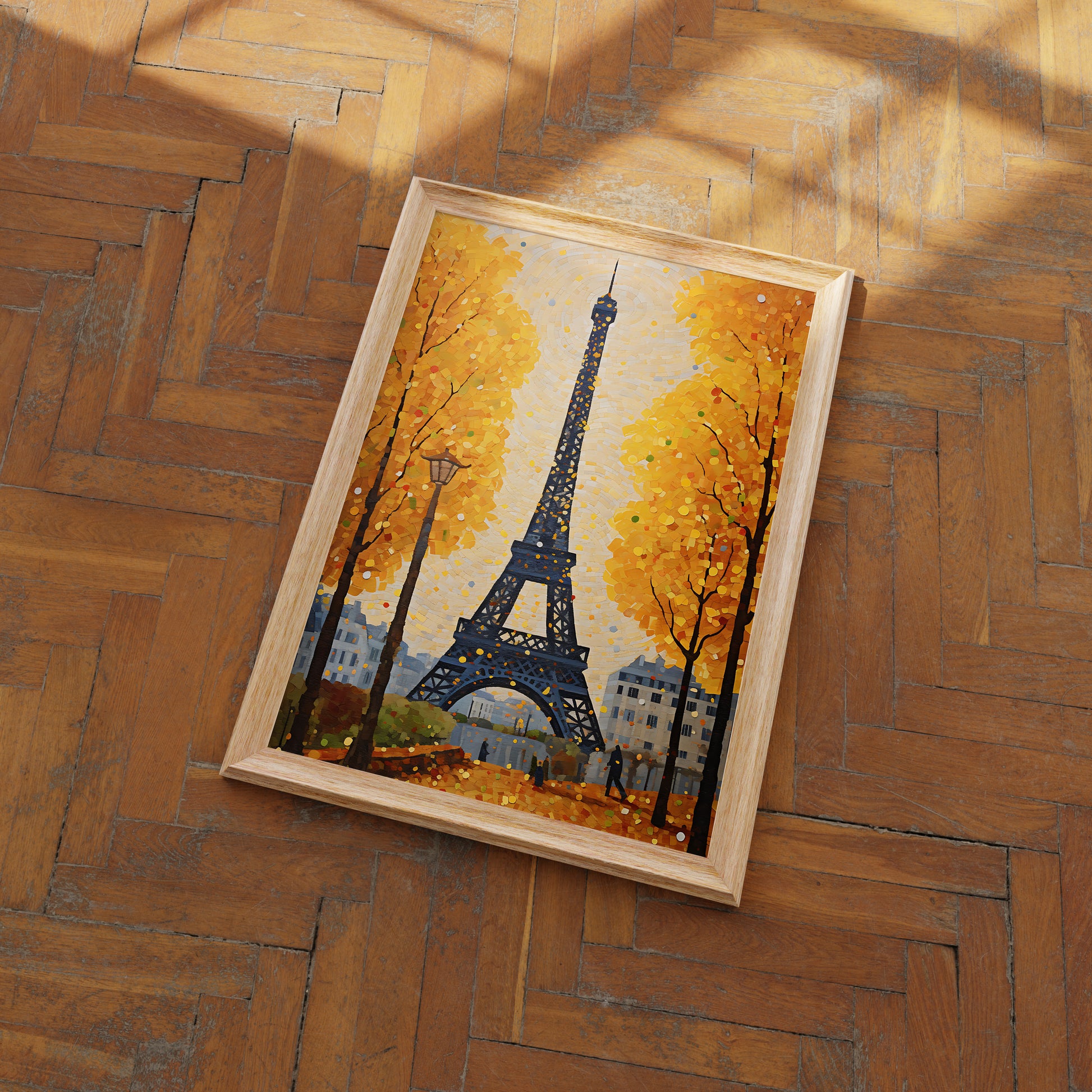 A framed painting of the Eiffel Tower with autumn trees on a herringbone wood floor.