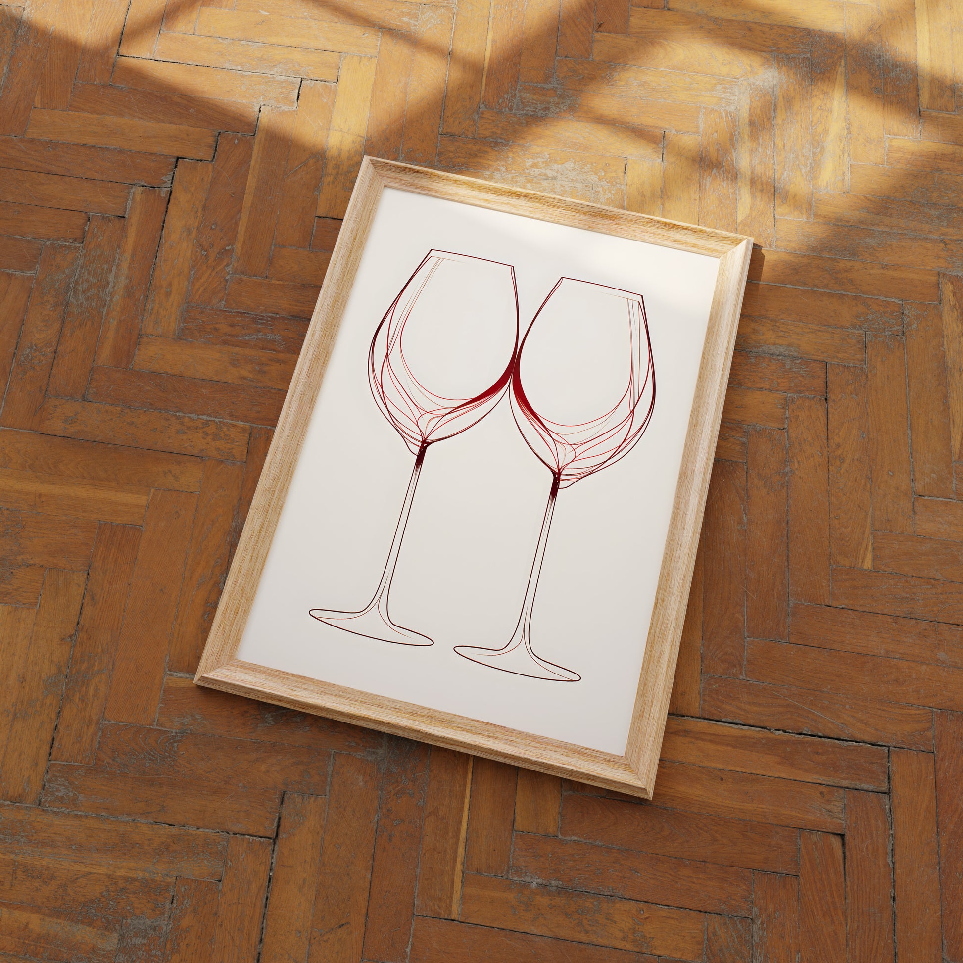 Two wine glasses artwork in a frame on a herringbone wood floor.