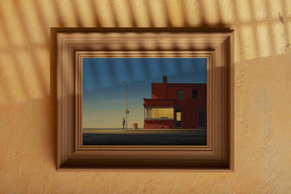 A framed painting on a wall depicting a desolate street scene with a building and a lone figure.