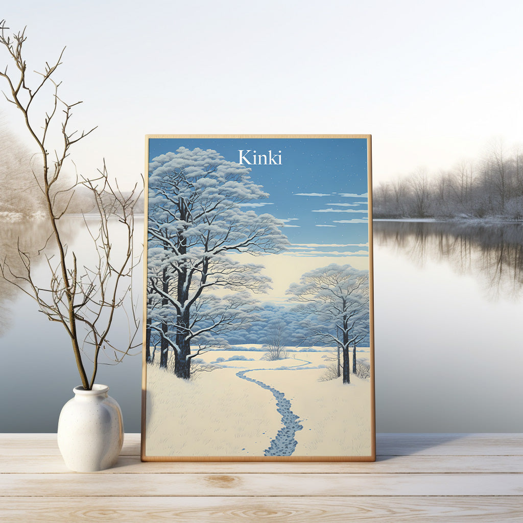 A framed Japanese-style winter landscape print displayed on a wooden floor with a vase beside it.