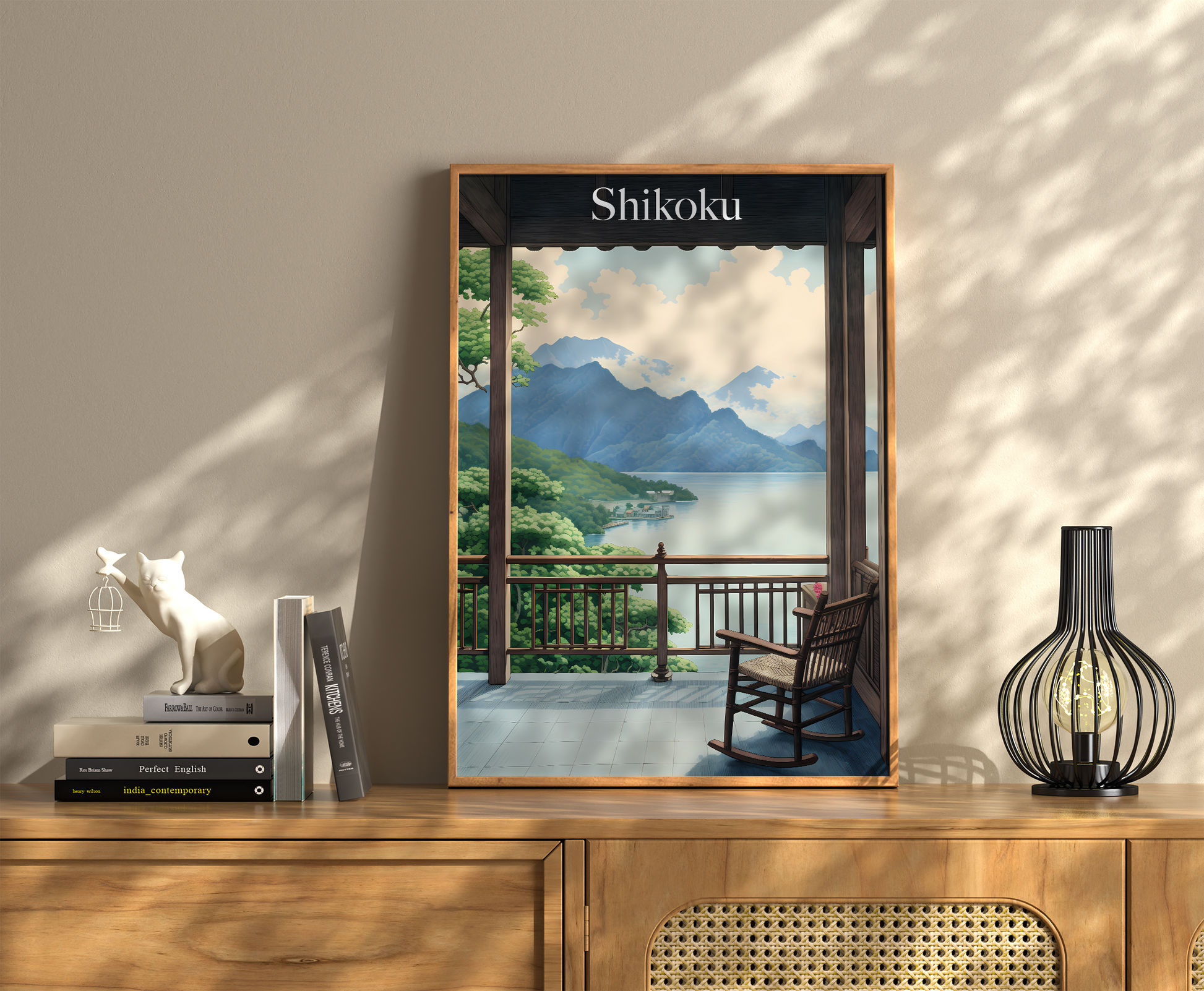 A framed picture of Shikoku landscape on a wall above a wooden cabinet with books and decor.