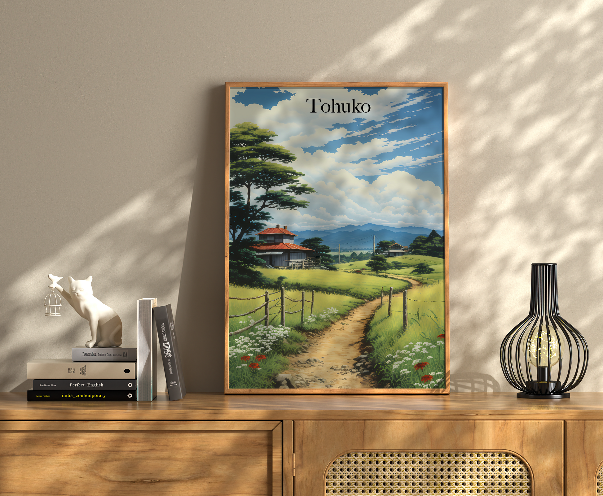 A framed travel poster of Tohoku with books and a vase on a wooden console.