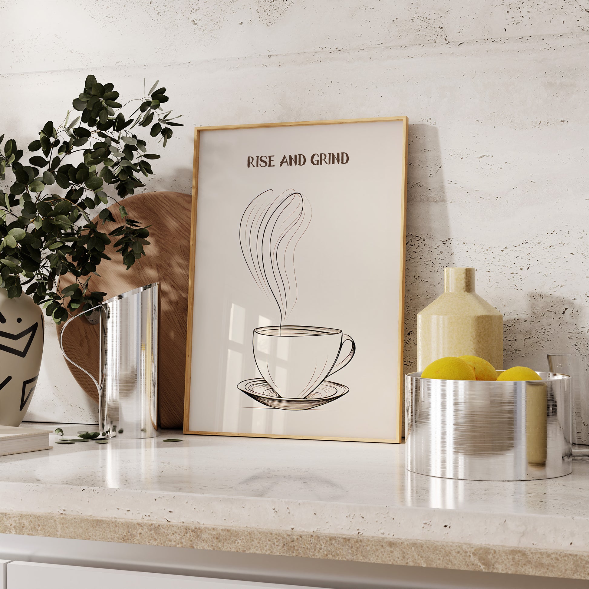 A framed poster with a coffee cup design and the text "Rise and Grind" on a kitchen countertop.