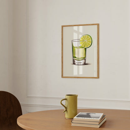 A framed illustration of a glass with lime above a table with a mug and books.