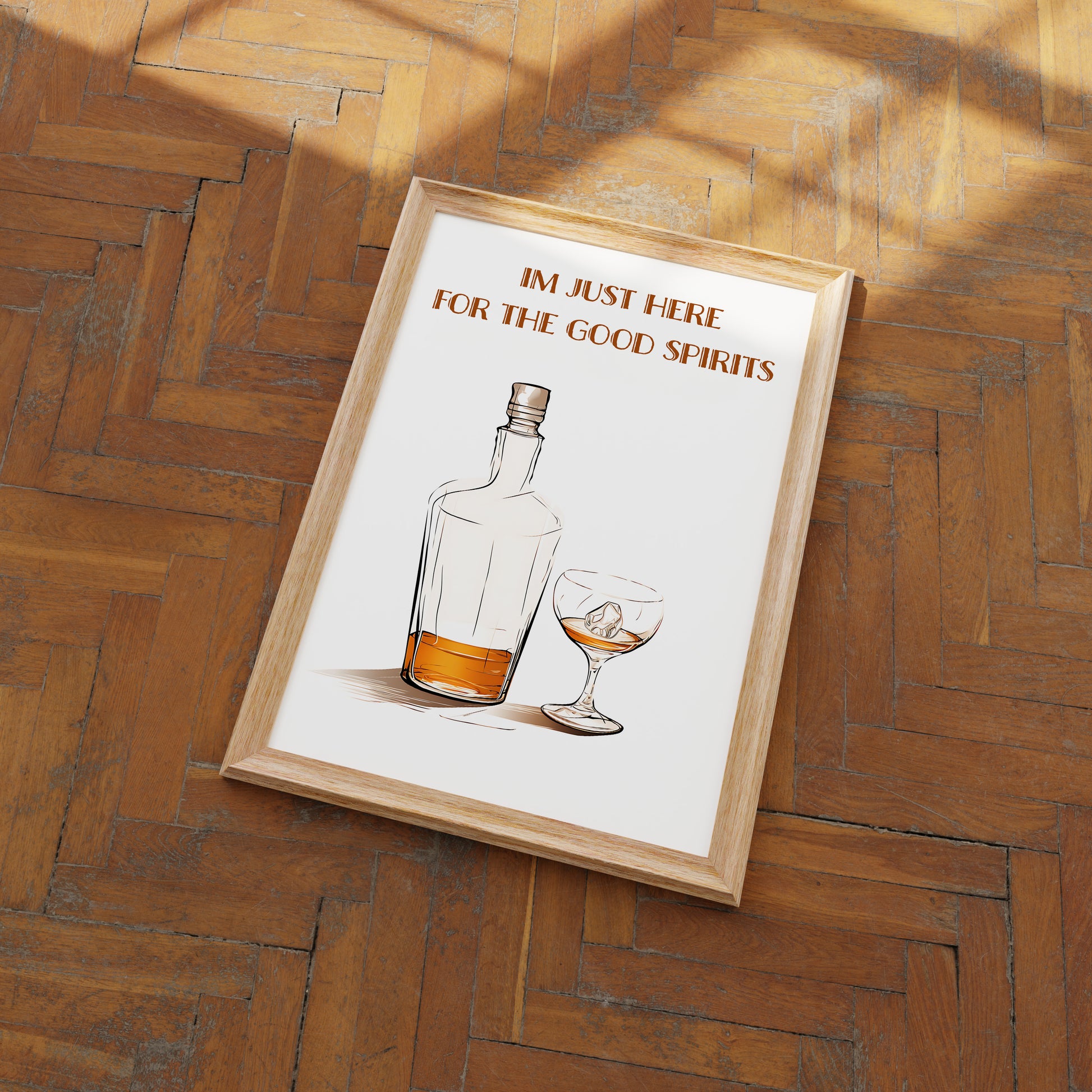 A framed poster with the phrase "I'm just here for the good spirits" above an illustration of a whiskey bottle and glass.