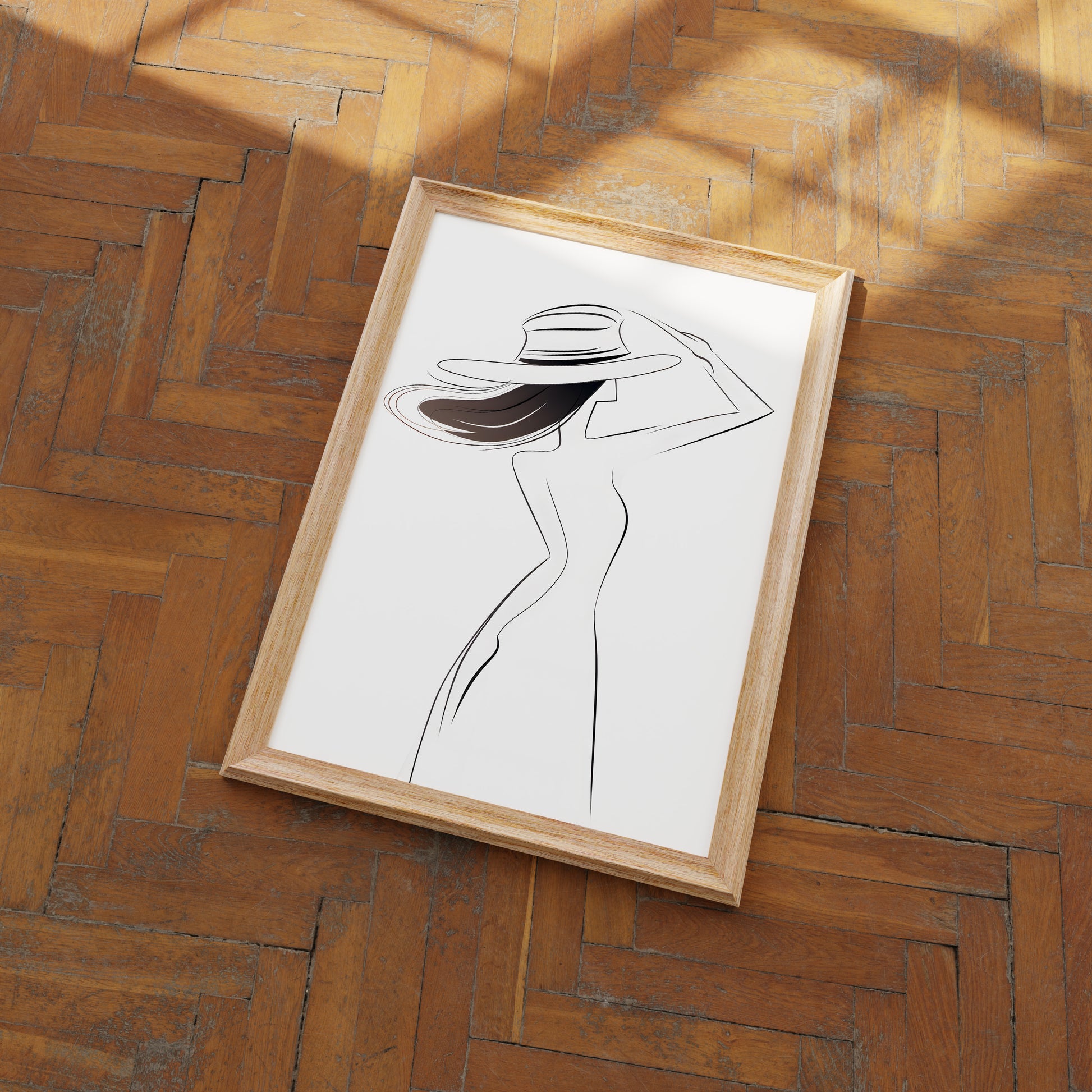 Elegant line art of a woman with a hat in a frame on a herringbone wood floor.